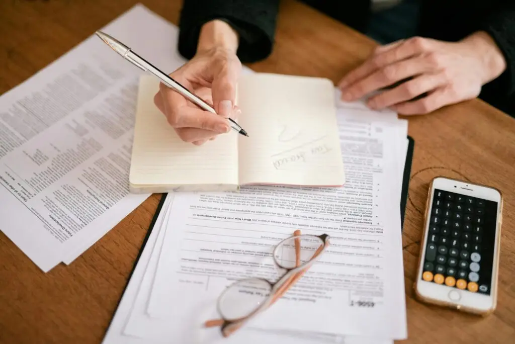 close-up-of-a-person-writing-in-a-notebook-with-documents-and-a-calculator-managing-finances-for-cn-tax-accounting-and-tax-firm-in-toronto-7247407-scaled accounting and tax